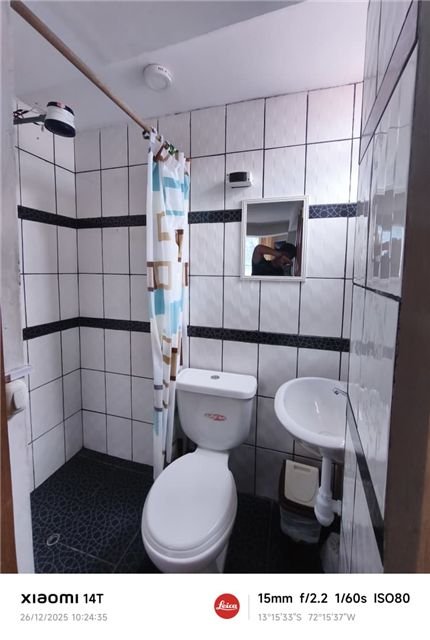 Baño con azulejos blancos y detalles oscuros
