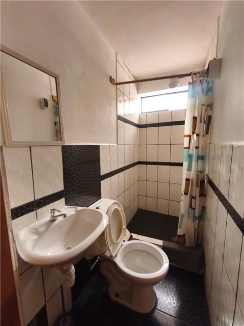 Baño de habitación con espejo y lavamanos