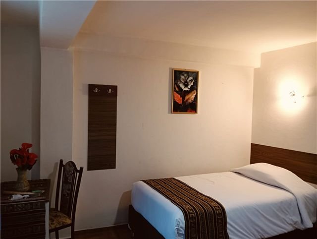 Cama junto a una lámpara de luz cálida