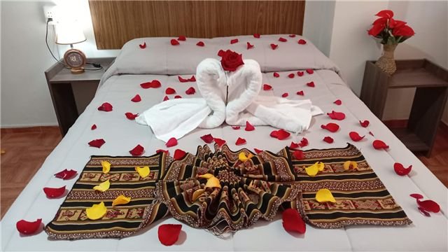 Cama preparada con pétalos y toallas decorativas