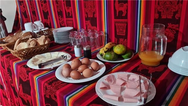 Mesa de desayuno con frutas, panes y bebidas