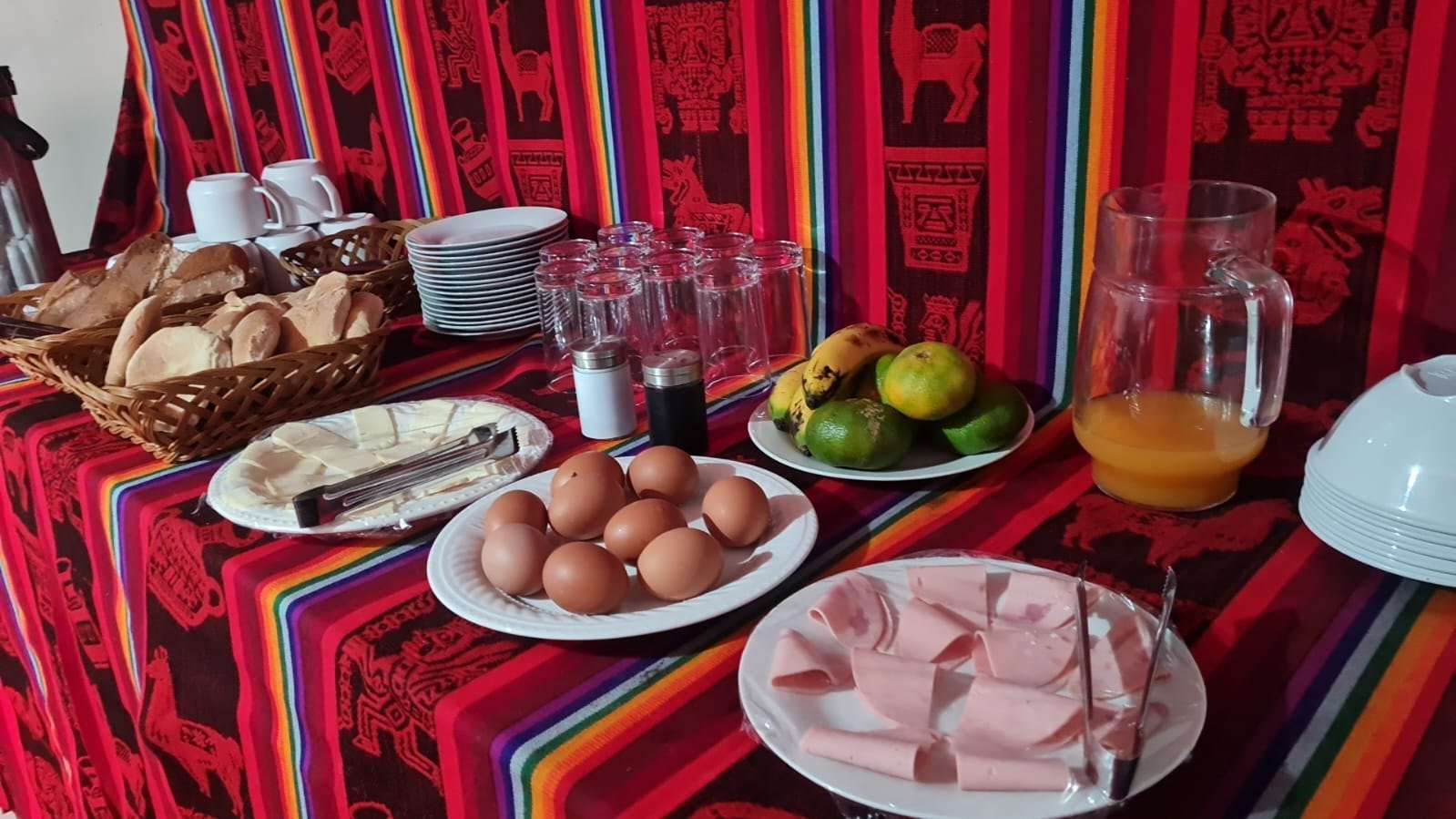 Mesa de desayuno con frutas, panes y bebidas