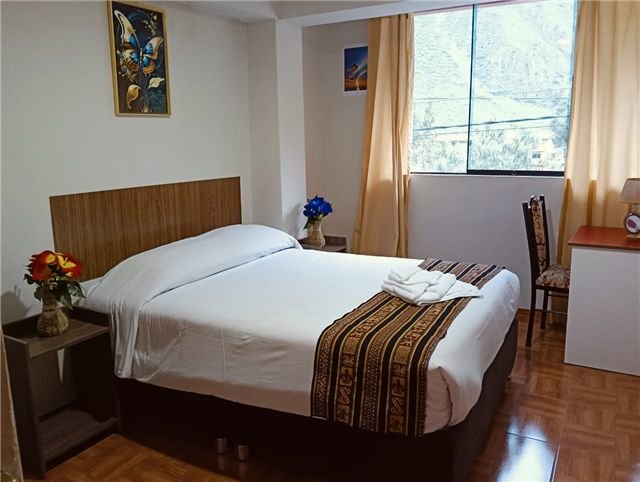 Cama junto a una ventana con vista a las montañas
